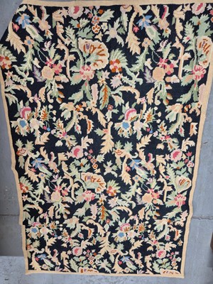 Lot 320 - A wool floral needle work black ground carpet...