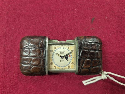 Lot 485 - A Movado travel watch with day, date and month...