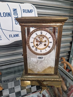 Lot 1667 - A glazed brass cased clock striking on a bell