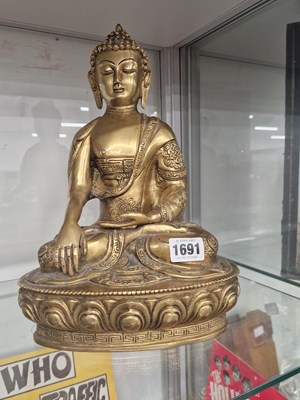 Lot 1691 - A polished brass figure of the Buddha