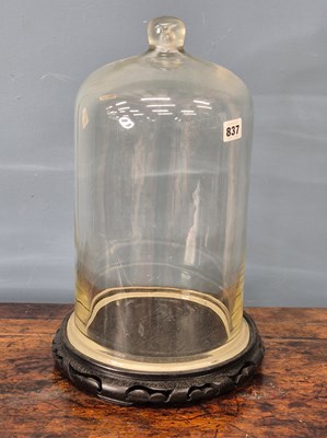 Lot 837 - A glass dome on a wood stand, the cylindrical...