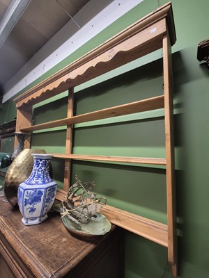 Lot 929 - A pine dresser rack with a wavy cornice over...