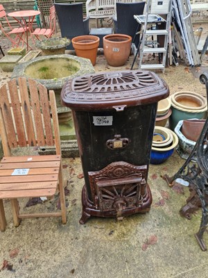 Lot 744 - A cast iron and enamel solid fuel stove room...