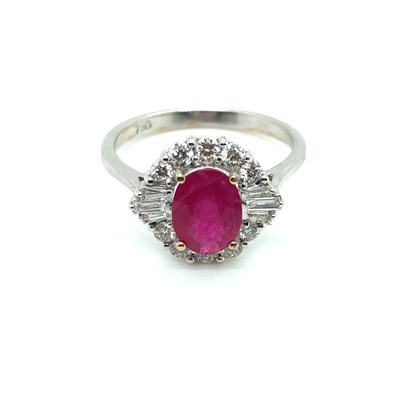 Lot 41 - A ruby and diamond cluster ring. The central...