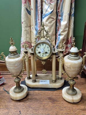 Lot 2067 - A cream agate portico clock garniture, the...