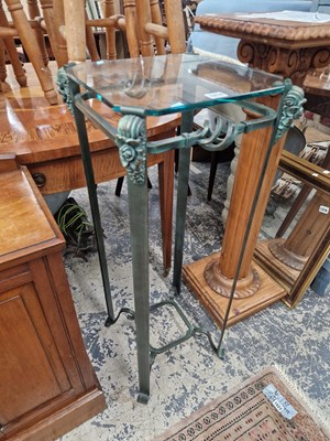 Lot 1214 - A Patinated brass and glass topped plant stand.