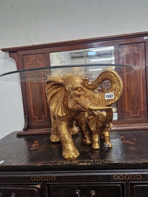 Lot 1587 - A coffee table with glass top supported on...