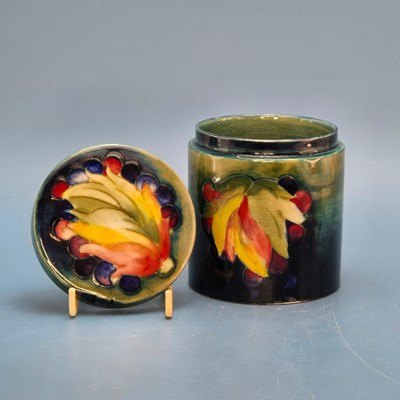 Lot 219 - A Moorcroft cylindrical covered jar slip...