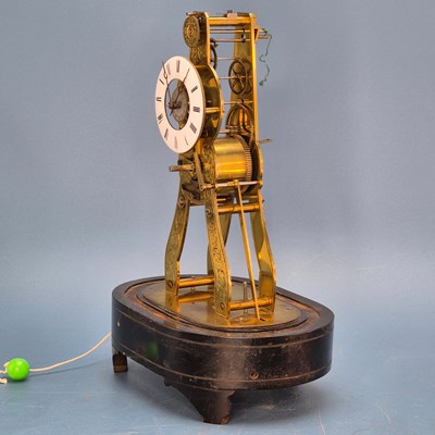 Lot 244 - A skeleton alarm clock under a glass dome, the...