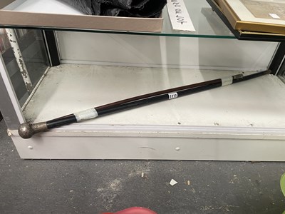 Lot 1111 - A silver topped ebonised walking cane together...