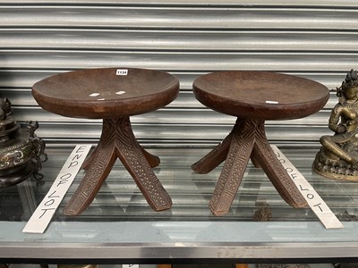 Lot 1134 - A pair of tribal wooden stools with dished...