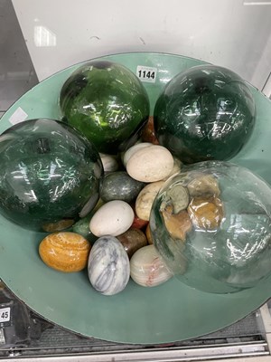 Lot 1144 - A bowl of stone eggs together with glass ball...