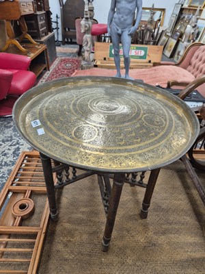 Lot 671 - A brass top table with folding stand.