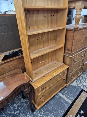 Lot 909 - A pine three drawer chest, a bookcase and a...