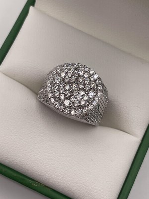 Lot 285 - A silver heavily set cubic zirconia ring....