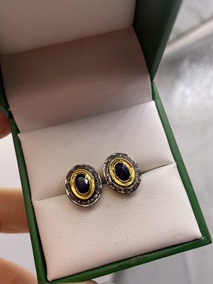 Lot 294 - A pair of oval sapphire and diamond halo stud...