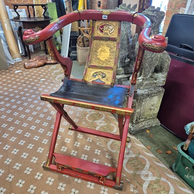 Lot 386 - A Chinese red lacquer folding armchair with a...