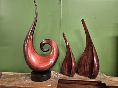 Lot 1052 - A set of three red lacquer sculptures.