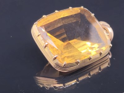Lot 18 - An antique large orange gem set pendant held...