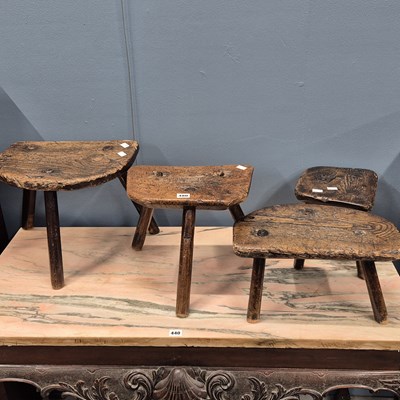 Lot 480 - A collection of four oak three legged milking...
