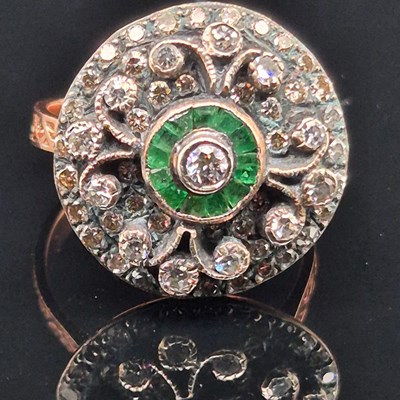 Lot 45 - An emerald and diamond ornate cluster ring....