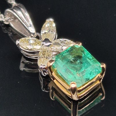 Lot 62 - An emerald and diamond pendant. The central...