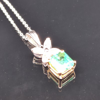 Lot 62 - An emerald and diamond pendant. The central...