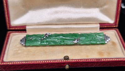 Lot 86 - A carved jade bar brooch in a fitted case. The...