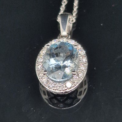 Lot 98 - An aquamarine and diamond cluster pendant. The...