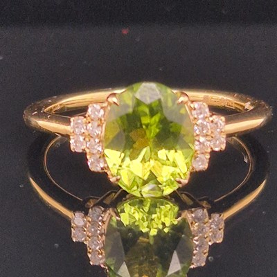 Lot 101 - A 9ct hallmarked gold oval peridot and diamond...