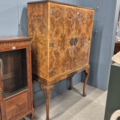 Lot 580 - An electrically lit walnut drinks cabinet on a...