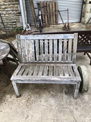 Lot 1252 - A pale teak garden seat.