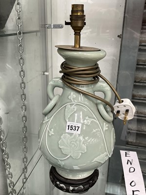 Lot 1537 - A ring handled celadon vase with vines in...