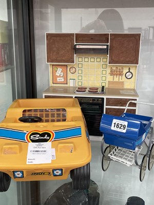 Lot 1629 - A toy cooker range, a pram and a yellow 'Sindy'...