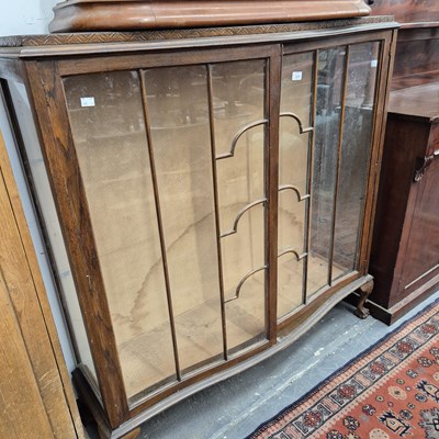 Lot 2216 - An oak serpentine front glazed display cabinet.