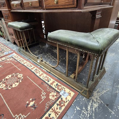 Lot 2246 - An antique leather-topped brass club fender....