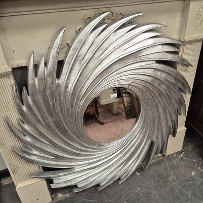 Lot 2357 - A modern wall mirror of vortex design.