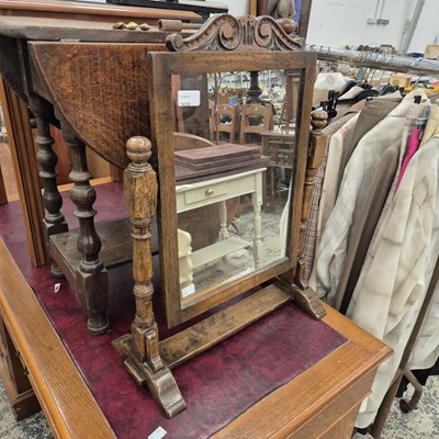 Lot 2638 - A Georgian-style oak swing mirror.