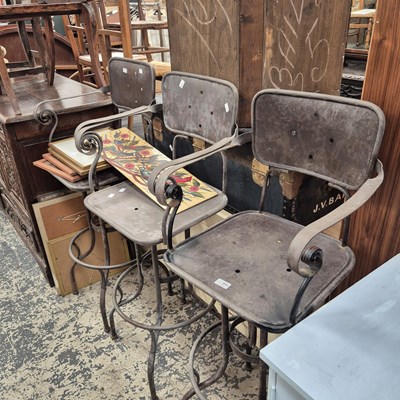 Lot 2662 - A set of three wrought-iron bar stools.