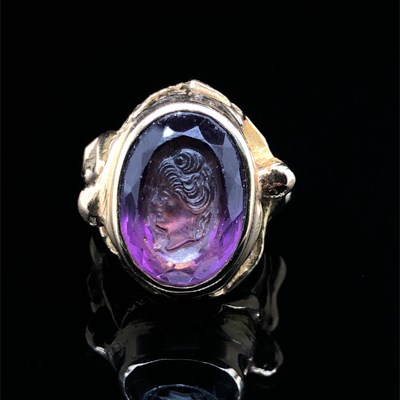 Lot 3 - A purple facet-cut & carved portrait cameo...