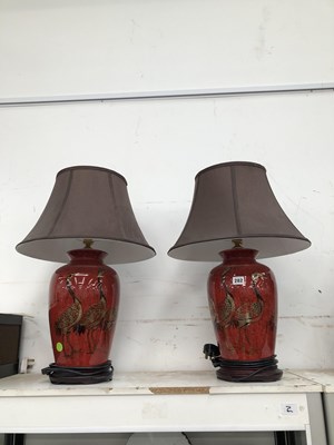 Lot 282 - A pair of red glazed table lamps.