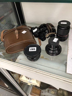 Lot 285 - A pair of binoculars and three camera lenses.
