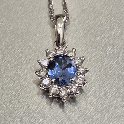 Lot 61 - A sapphire and diamond oval cluster pendant...