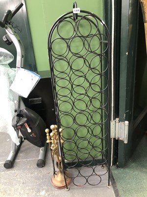 Lot 144 - A brass companion set and an iron wine rack.