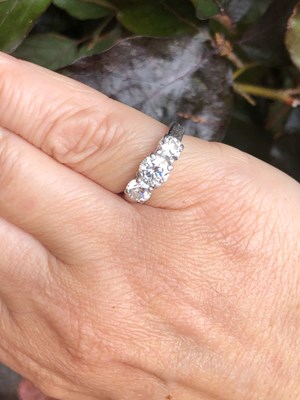 Lot 84 - A platinum hallmarked three-stone diamond,...