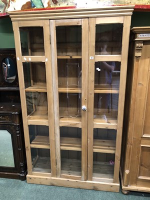 Lot 48 - A glazed pine display cabinet, the central...