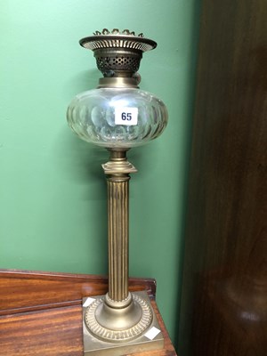 Lot 65 - An oil lamp with a clear glass receiver raised...