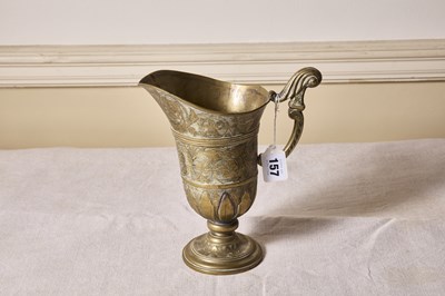 Lot 157 - An early brass helmet form jug, overall etched...