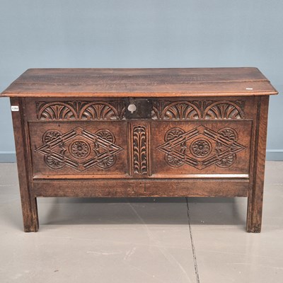 Lot 1394 - An 18th-century oak coffer with carved frieze...