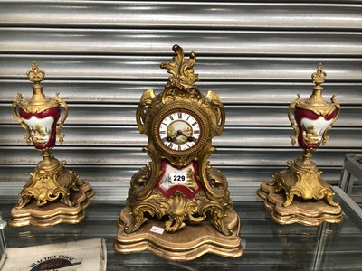 Lot 229 - A gilt metal and claret ground porcelain clock...